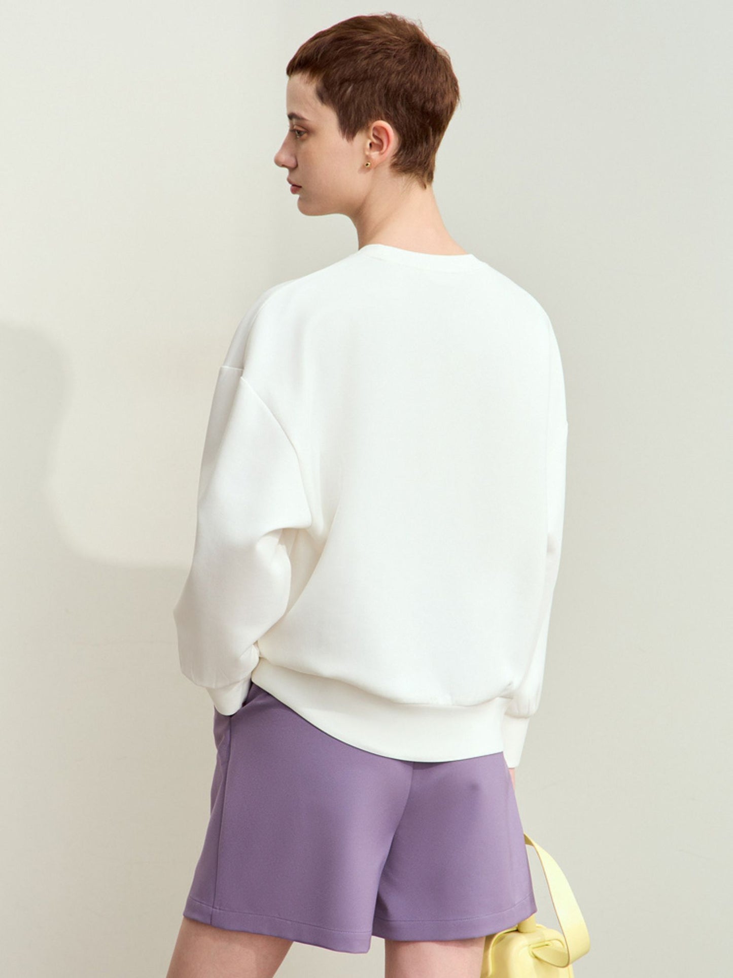 Bagvisning af hvid sweatshirt med løs pasform og afslappet look.