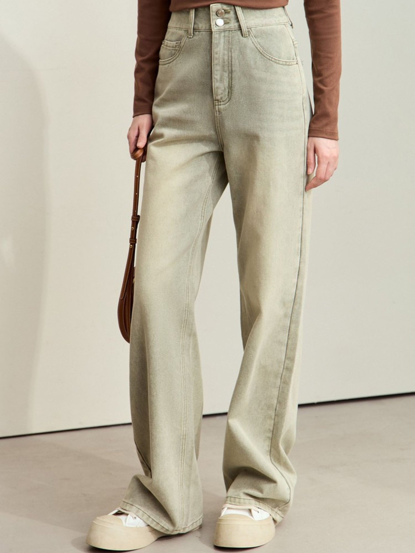 Sidevisning af lysegrønne jeans med lav talje og afslappet snit.