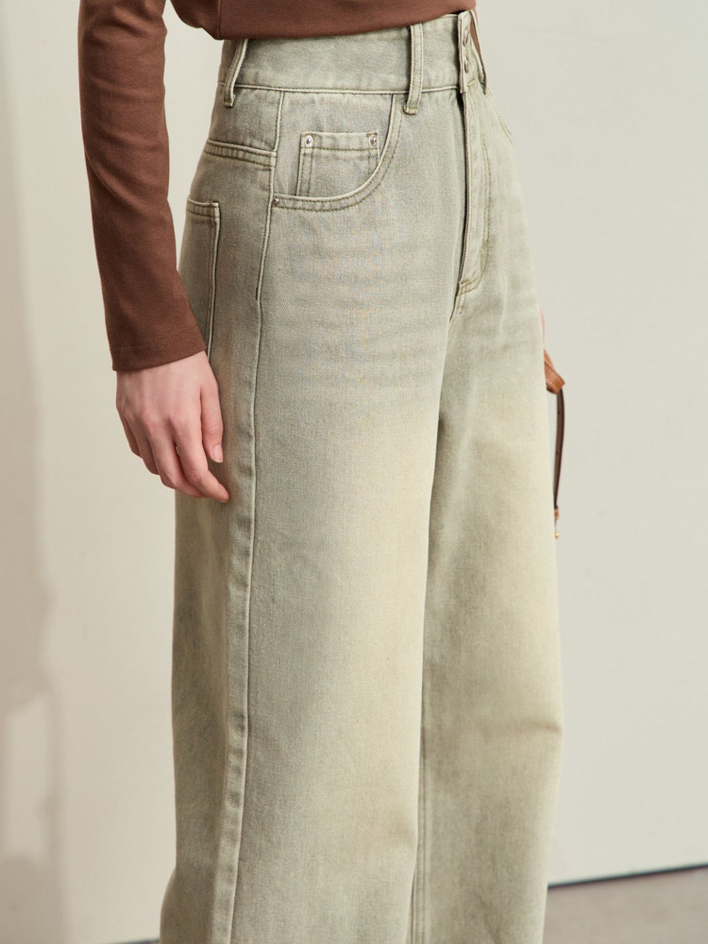Nærbillede af ben og lommer på lysegrønne jeans.