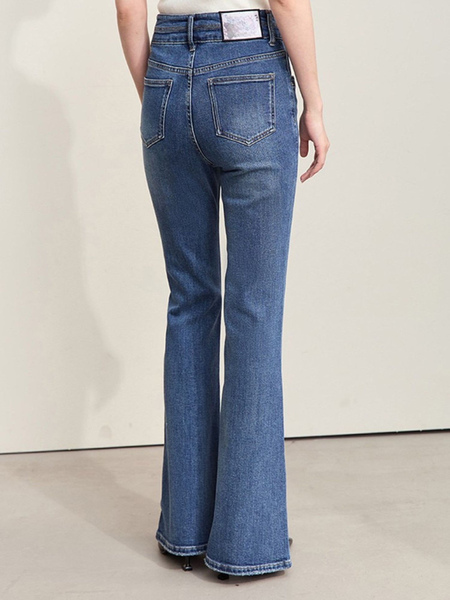 Bagfra-visning af blå jeans med klassiske lommer.