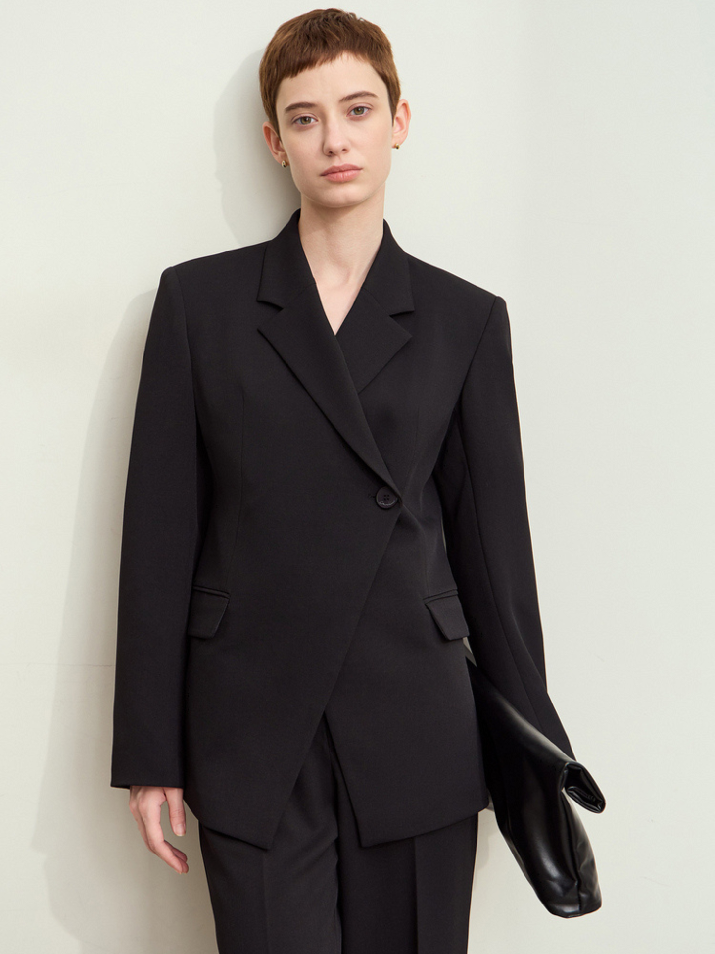 Model i sort blazer og bukser med sort taske, frontvisning.