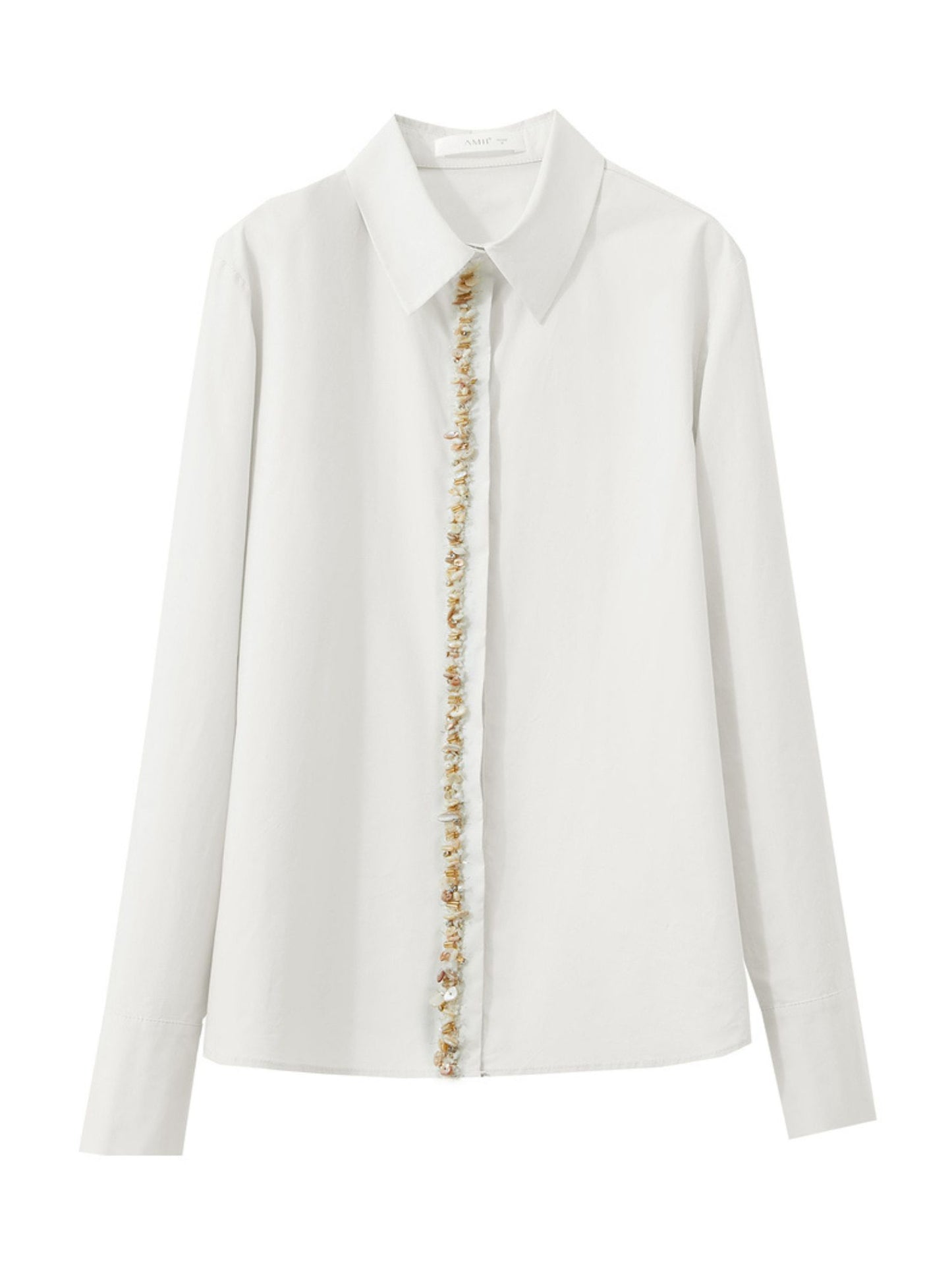 Hvid skjorte lagt fladt, viser perleknapper og klassisk krave.