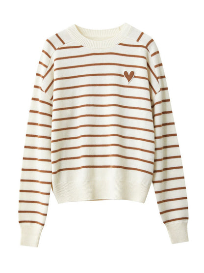 Beige og hvid stribet sweater lagt fladt med brunt hjerteprint.