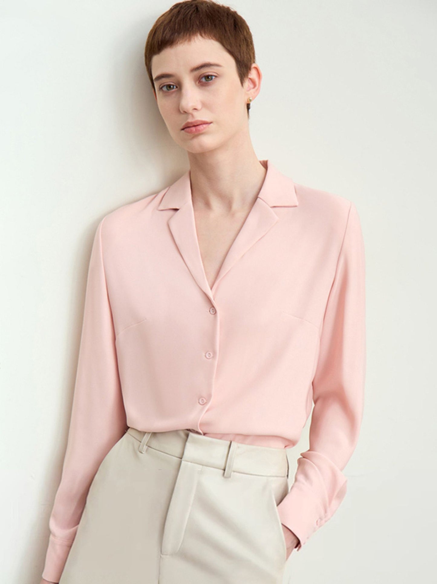 Skrå vinkel af lys rosa skjorte med løs pasform og åben krave.