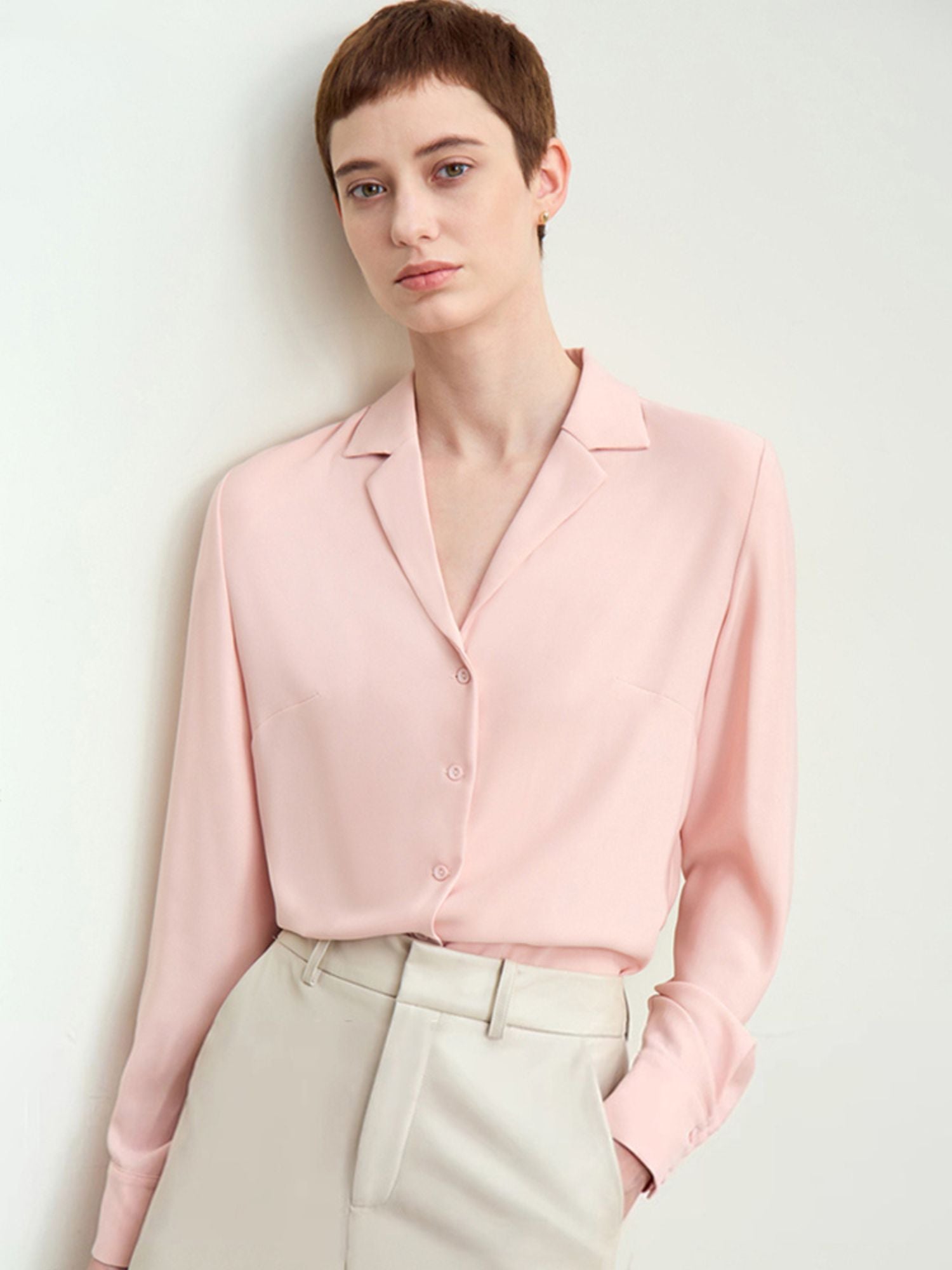 Skrå vinkel af lys rosa skjorte med løs pasform og åben krave.