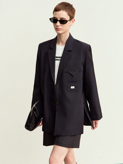 Frontvisning af sort blazer og nederdel med solbriller.