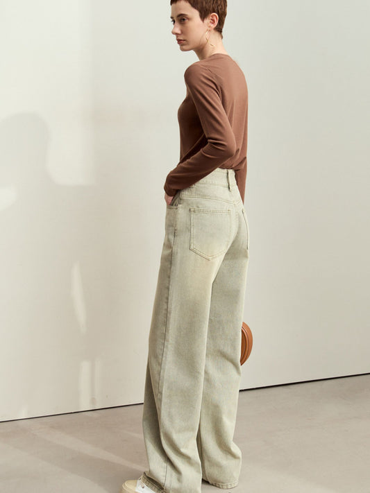Model i brun top og lysegrønne jeans med vide ben og afslappet pasform.