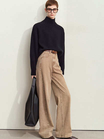 Model iført sort trøje og brede beige fløjlsbukser med høj talje.
