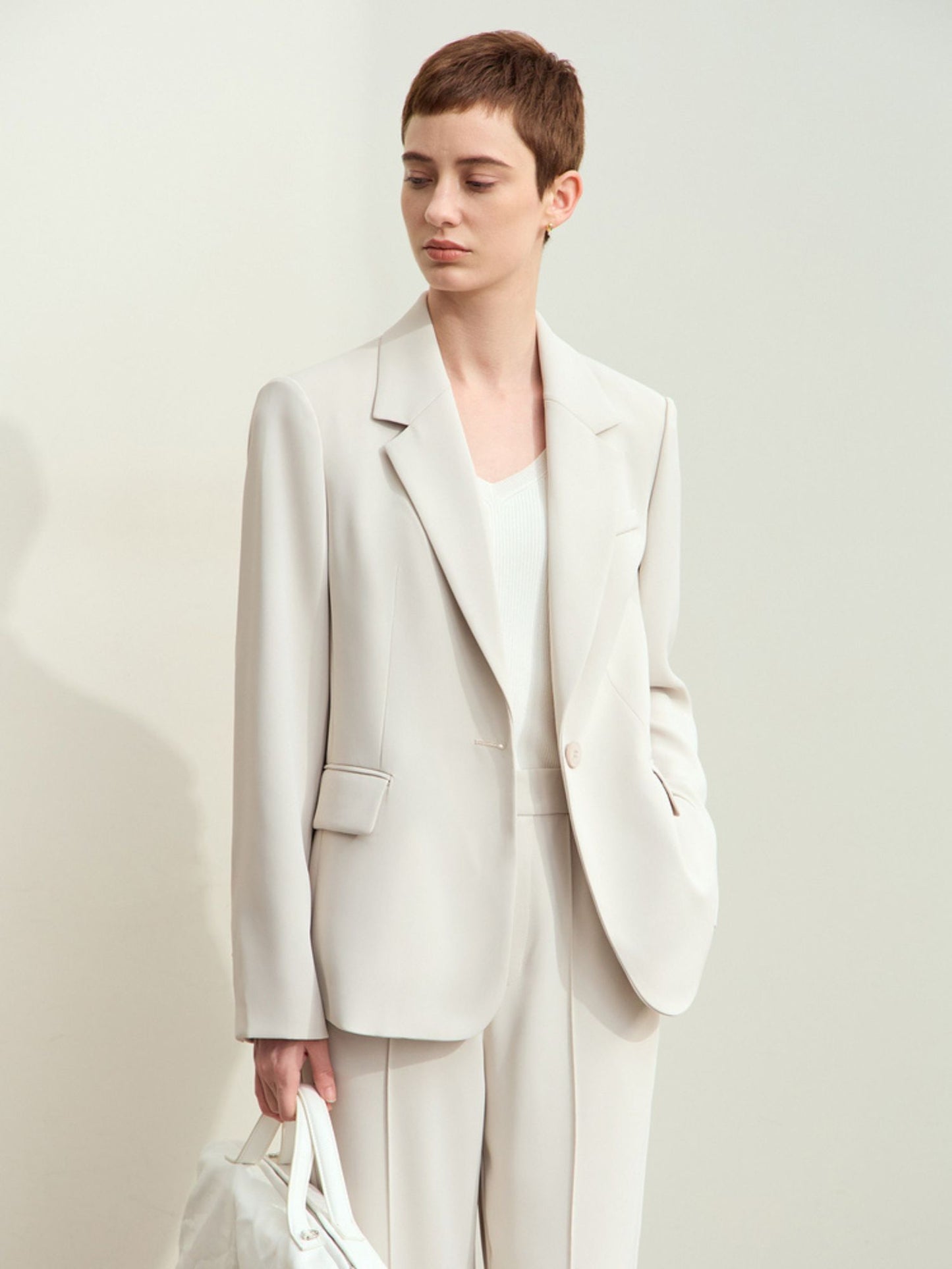 Model iført lys beige oversized blazer og matchende bukser.