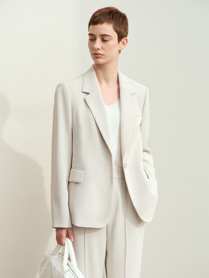 Model iført lys beige oversized blazer og matchende bukser.