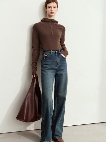 Model i brun top og mørkeblå jeans med lige ben og stor brun taske.