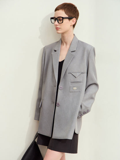 Grå blazer båret åbent med solbriller og sort taske.