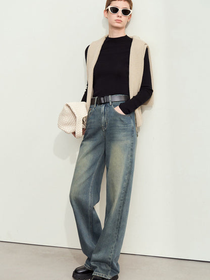 Jeans stylet med sort top og solbriller, set forfra.