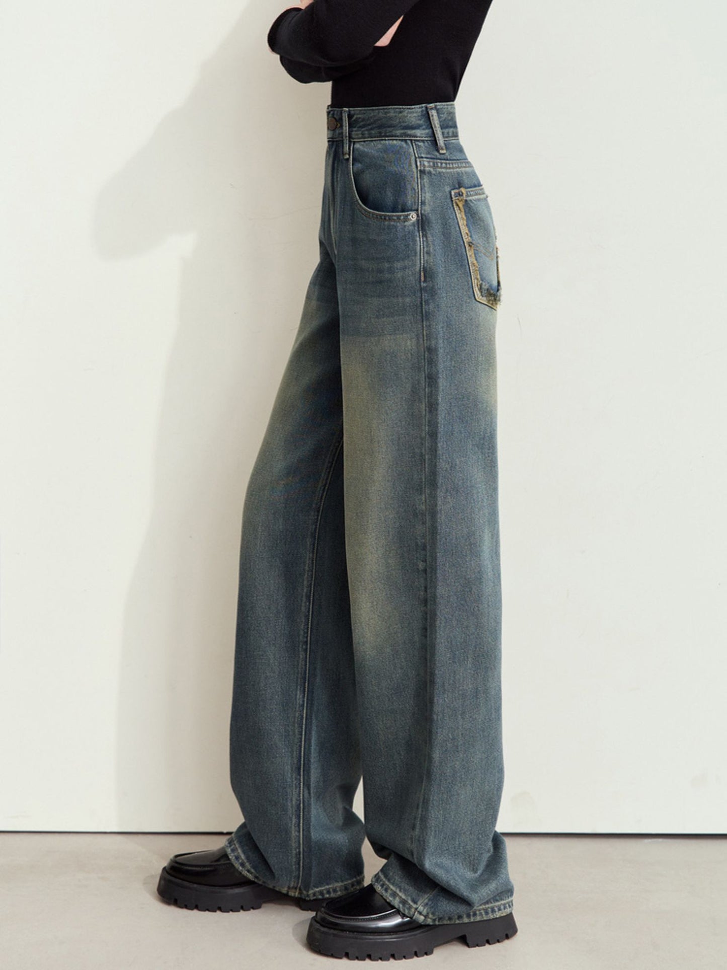 Sidevisning af jeans med høj talje og lige ben.