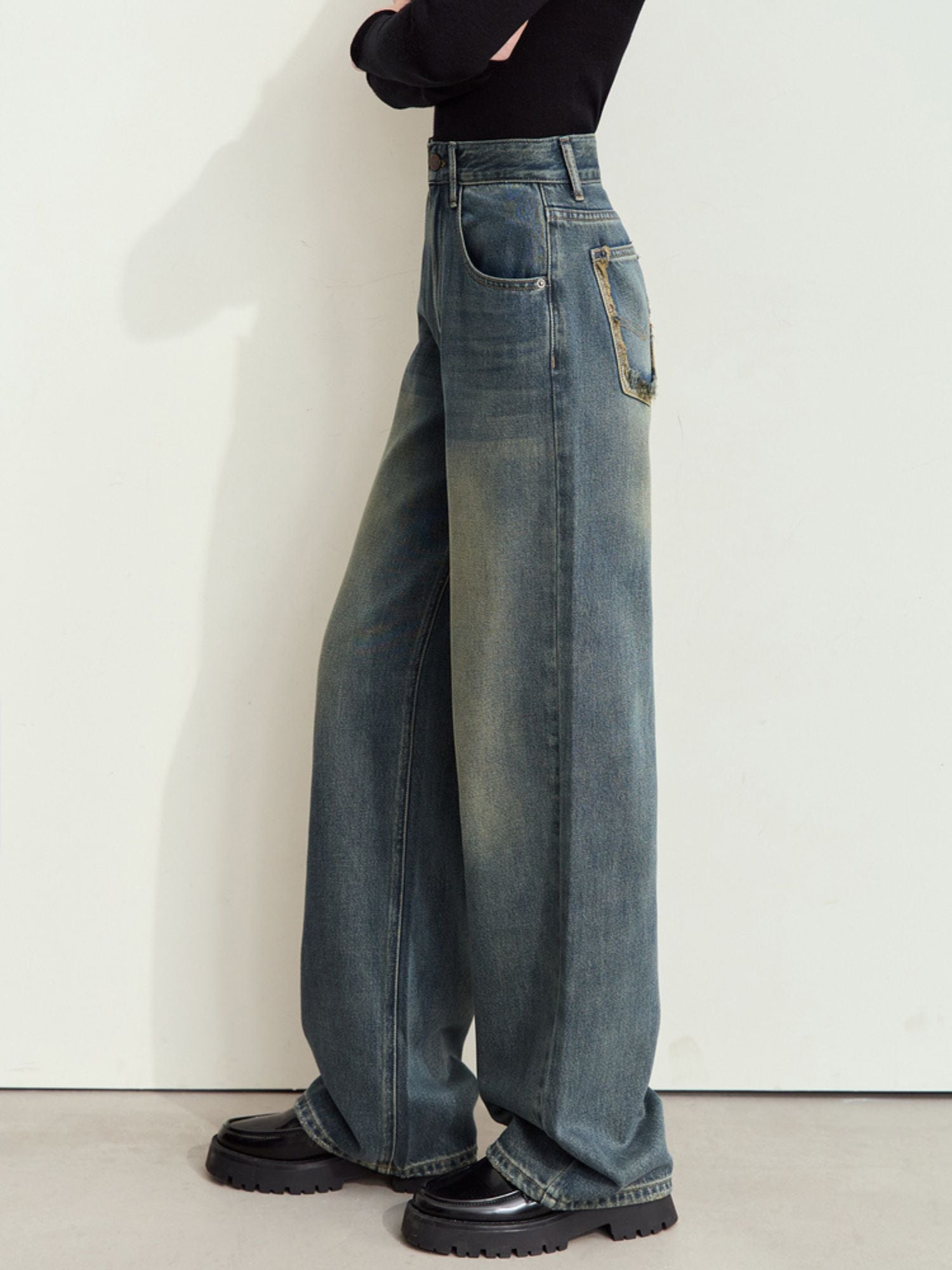 Sidevisning af jeans med høj talje og lige ben.