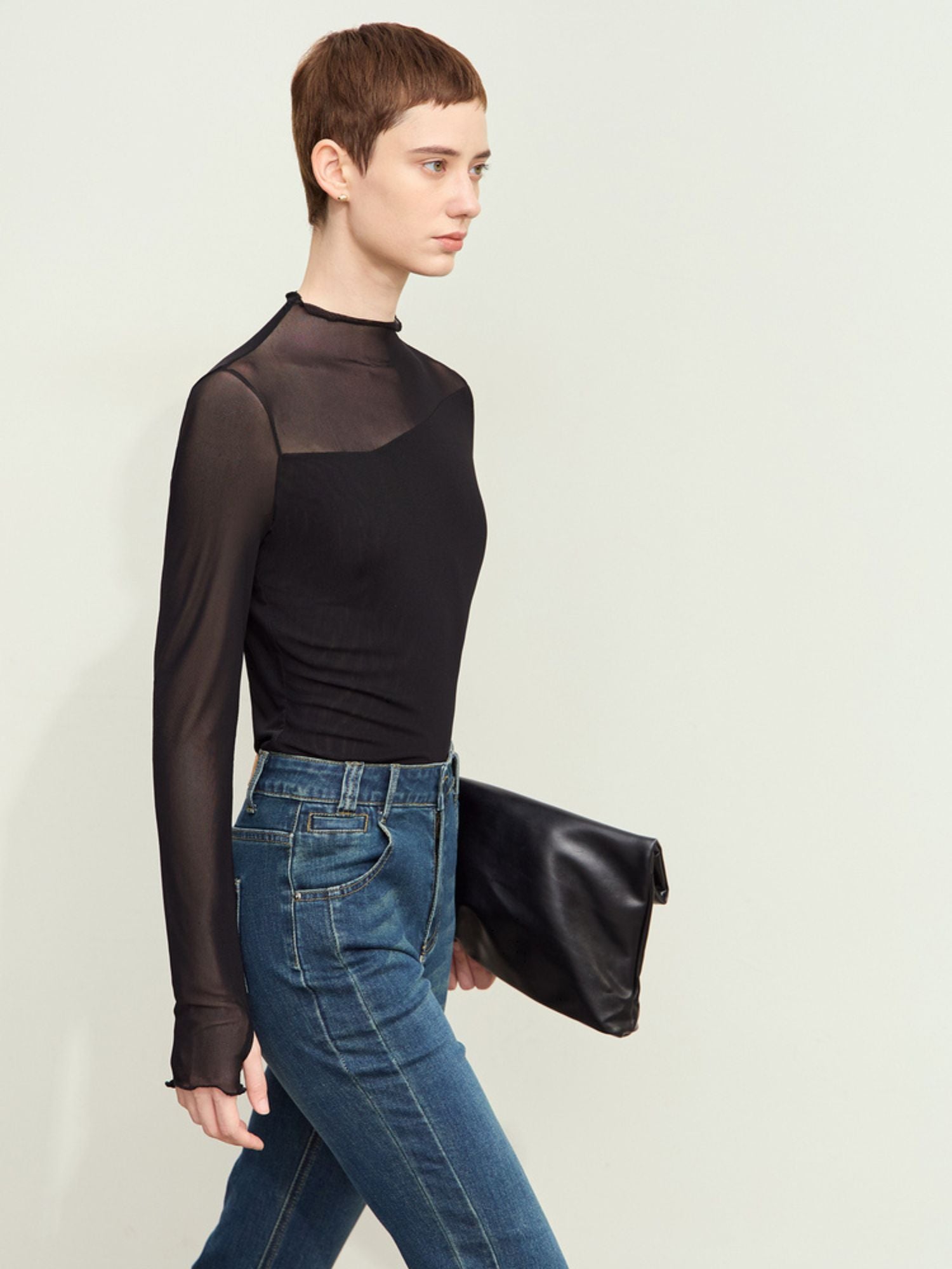 Sidevisning af sort mesh-bluse med lange ærmer og tætsiddende pasform.