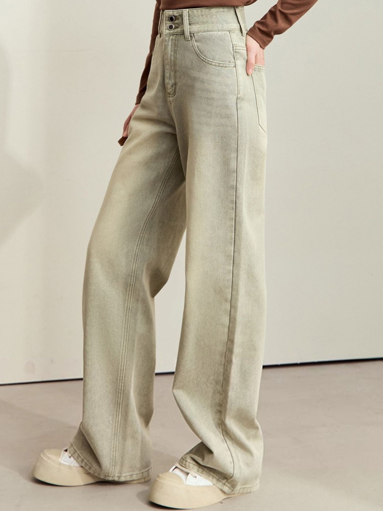 Jeans med brede ben og synlige sømme, vist fra skrå vinkel.