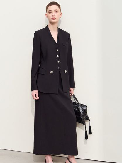 Sort blazer med v-udskæring, båret med taske i hånden.