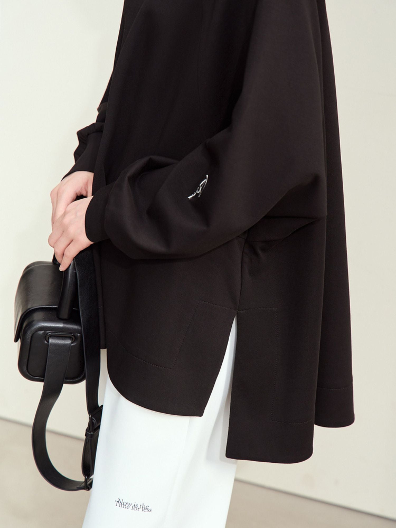 Nærbillede af sort oversized sweatshirt med løs pasform og faldende skuldre.