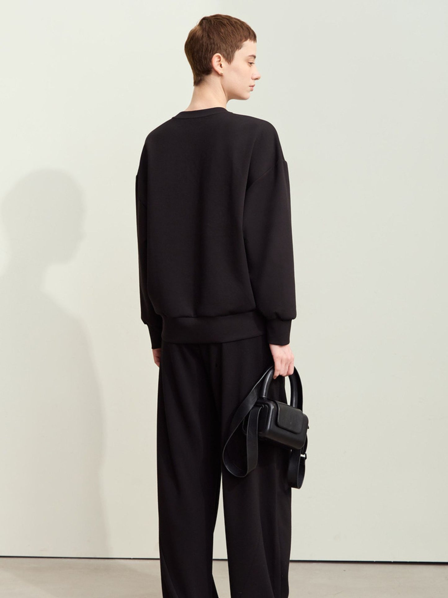 Bagvisning af sort sweatshirt i løs pasform.