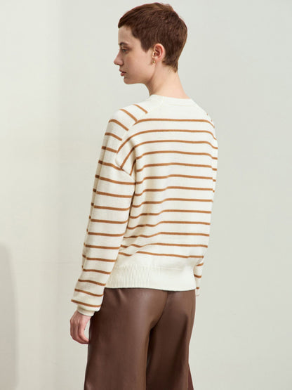 Beige sweater med brune striber og broderet hjerte, model ser til siden.