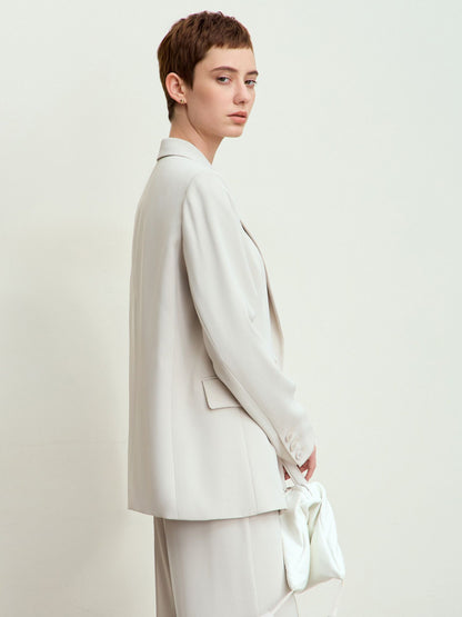 Sidevisning af blazer med let dropped skuldersøm og lommedetaljer.