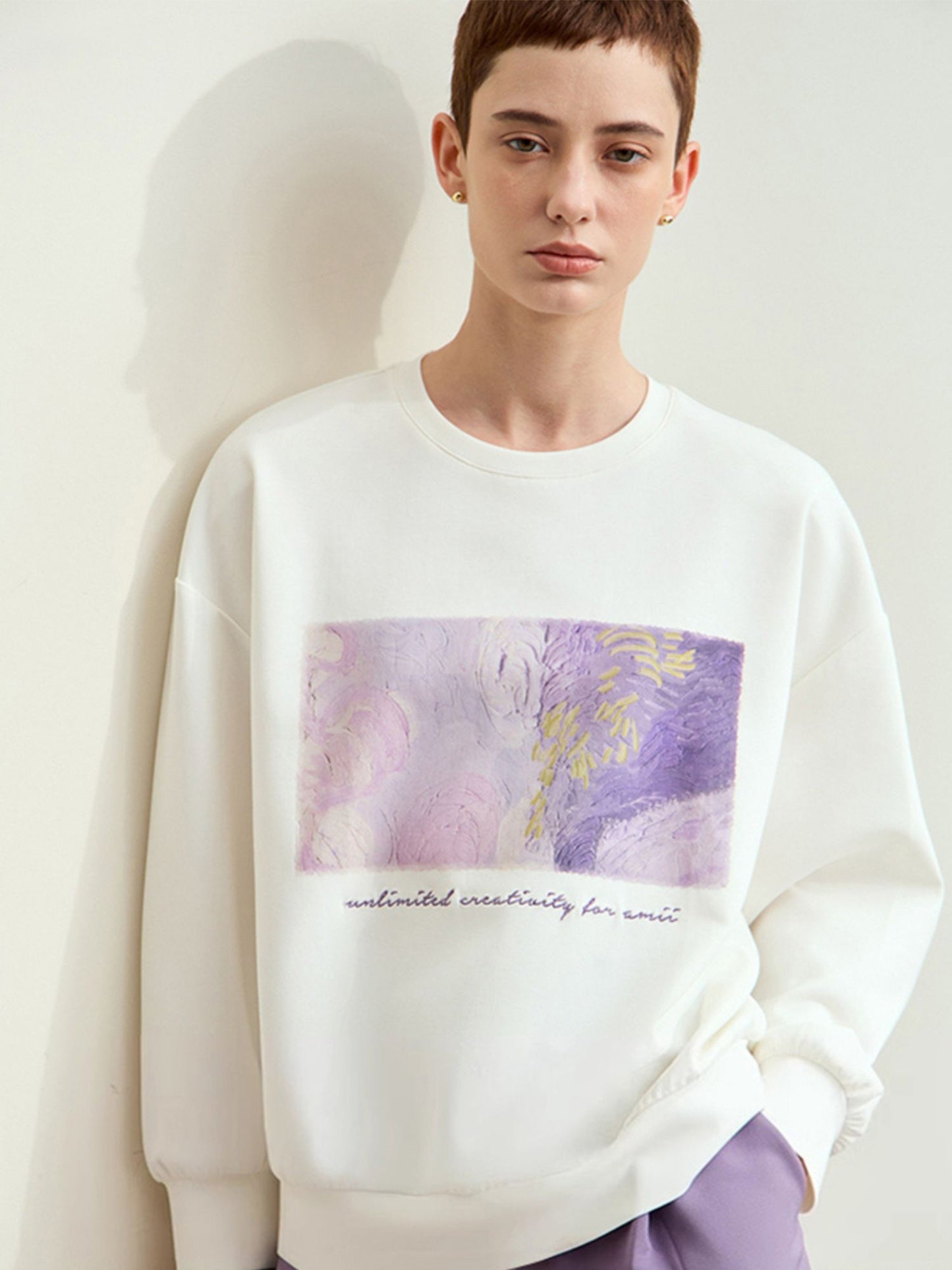 Model i hvid sweatshirt med samme lilla print og lilla shorts.