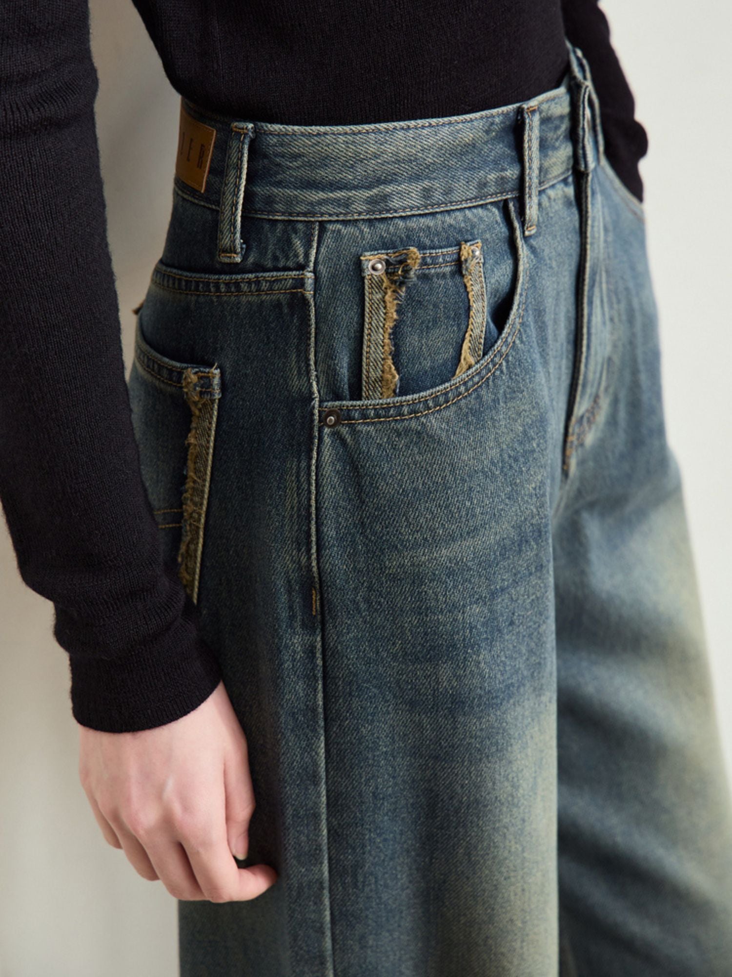 Nærbillede af jeans' linning og forlommer.