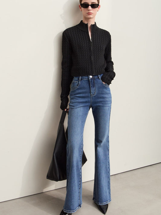 Model i sort skjorte og blå bootcut jeans med hæle og solbriller.