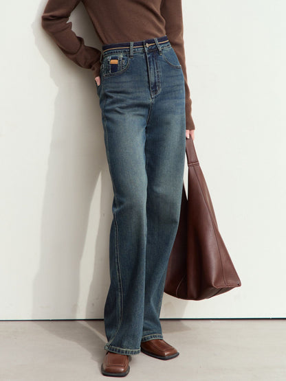 Nærbillede af front og lomme med guldmærke på mørkeblå jeans.