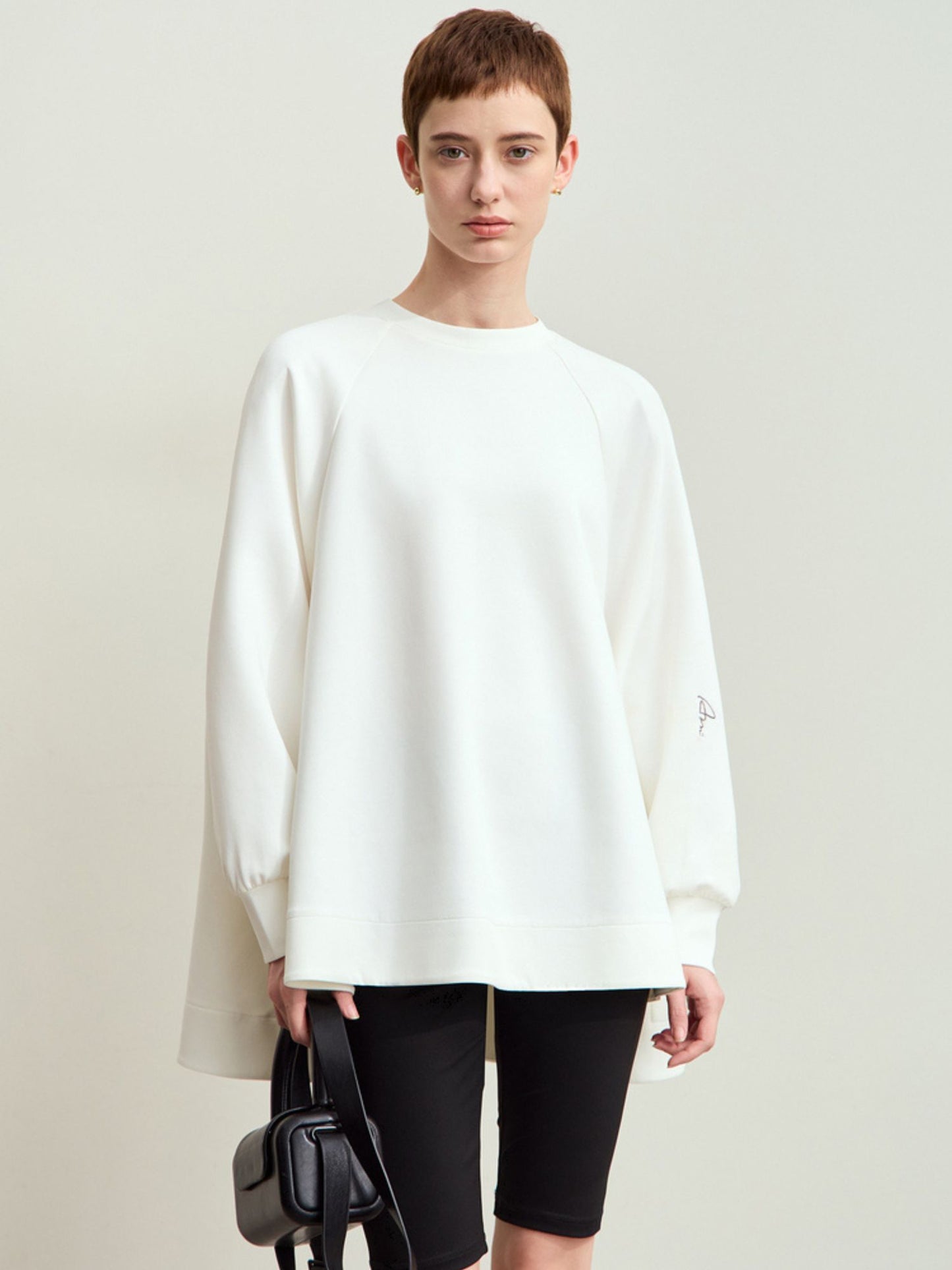 Frontvisning af hvid oversized sweatshirt med lange ærmer.