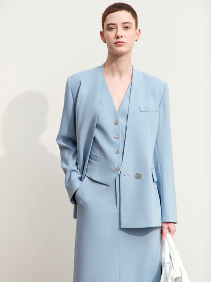 Model iført lyseblå blazer med v-udskæring og to knapper.