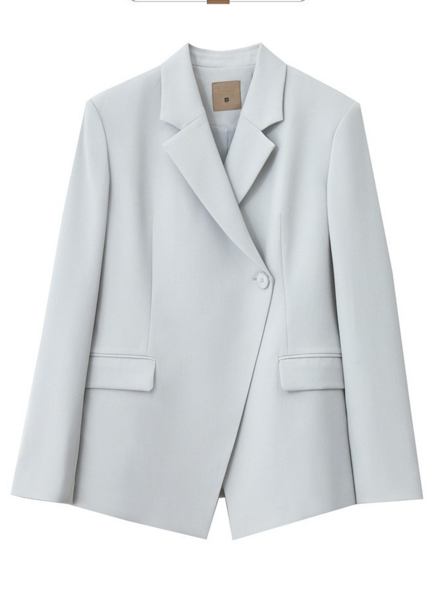 Nærbillede af blazerens ærmeknapper og stofstruktur.