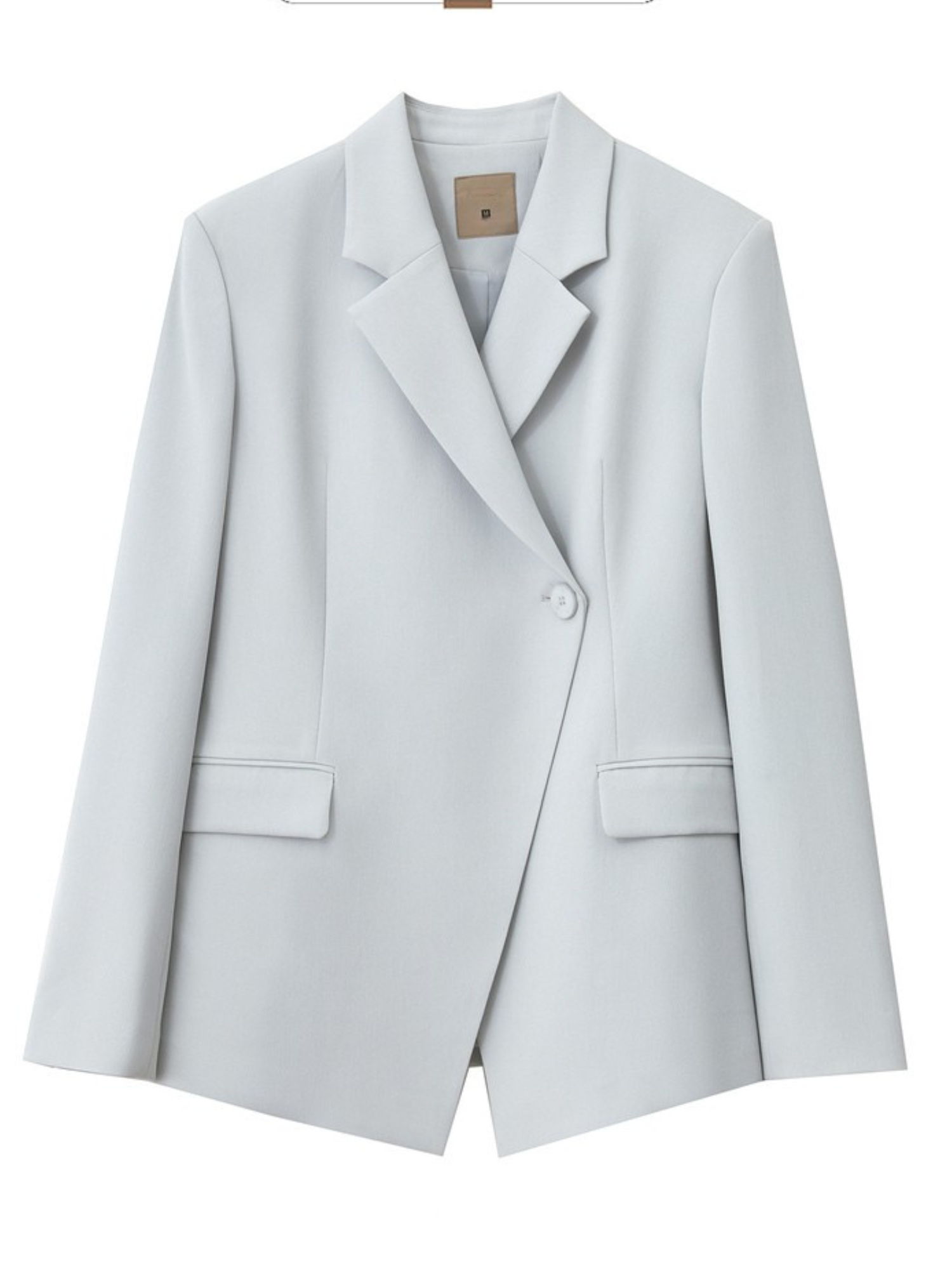 Nærbillede af blazerens ærmeknapper og stofstruktur.