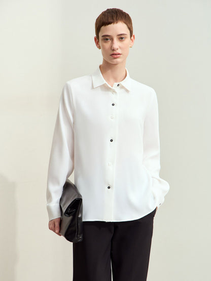 Frontvisning af hvid skjorte med lange ærmer, bæres løst af model.