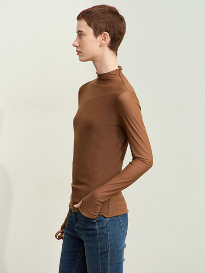 Skrå vinkel af brun bluse med høj hals og diskrete syninger.