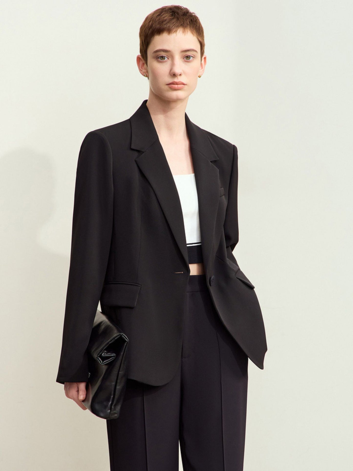 Sort jakkesæt vist mod mørk baggrund, frontvisning.