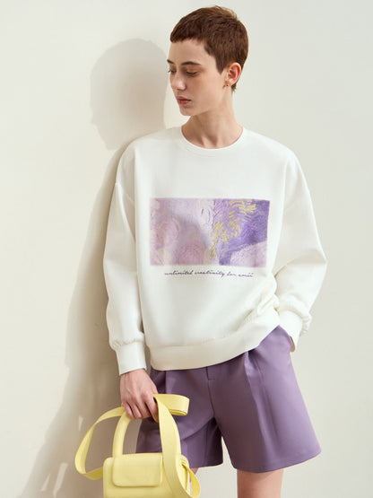 Hvid sweatshirt med kunstprint og model der holder gul taske.