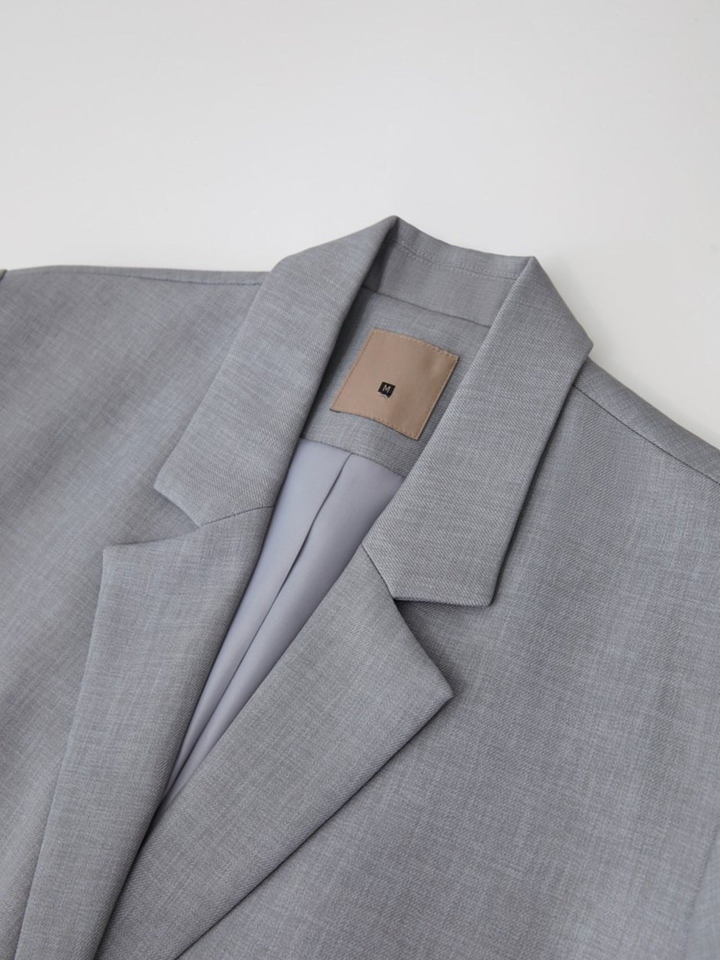 Nærbillede af blazerens revers og brystlomme.